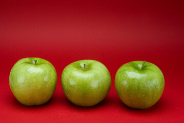 Green apples on a red background