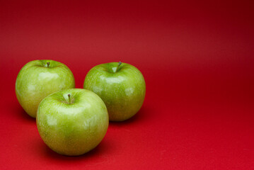 Green apples on a red background