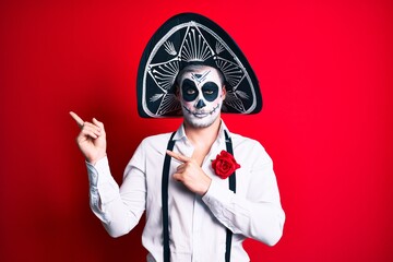 Man wearing day of the dead costume pointing with fingers to the side skeptic and nervous, frowning upset because of problem. negative person.