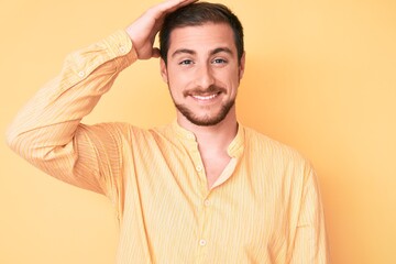 Young handsome man wearing casual clothes confuse and wonder about question. uncertain with doubt, thinking with hand on head. pensive concept.