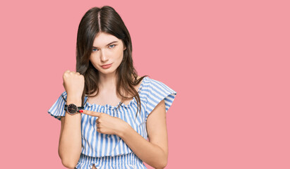 Young beautiful caucasian girl wearing casual clothes in hurry pointing to watch time, impatience,...