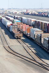 Multiple freight trains at a trainyard shipping terminal hub.