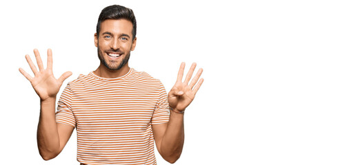 Handsome hispanic man wearing casual clothes showing and pointing up with fingers number nine while...