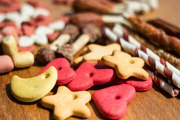 Dog tasty colored biscuits on wooden background 