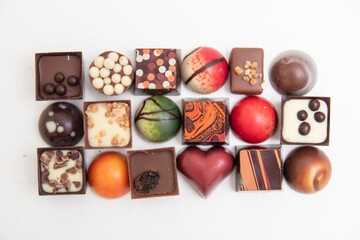 lot of variety chocolate pralines, top view of various chocolate pralines isolated on white background