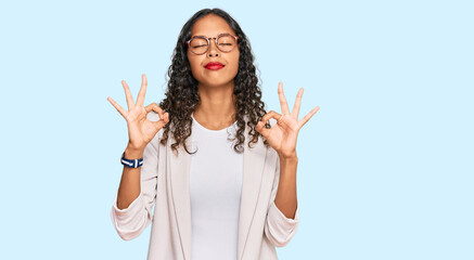 Young african american girl wearing business clothes relaxed and smiling with eyes closed doing meditation gesture with fingers. yoga concept.