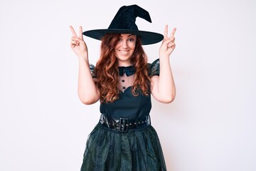 Young beautiful woman wearing witch halloween costume posing funny and crazy with fingers on head as bunny ears, smiling cheerful