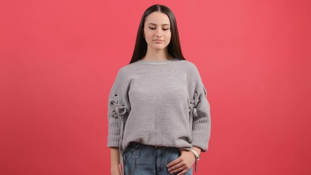 Frustrated young woman tired of life, shooting into head with finger pistol, killing herself to stop boredom, desperate emotions. isolated on red background.