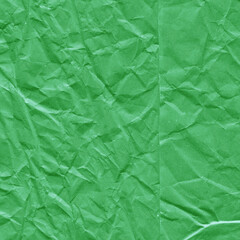 Green vintage and old looking crumpled paper background. Retro cardboard texture. Grunge paper for drawing. Ancient book page. Present wrapping.