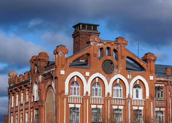 Close-up view of the facade of an old red brick building in the modernist style, late 19th century. Historical architectural and industrial complex " Morozovsky quarter", Tver, Russia