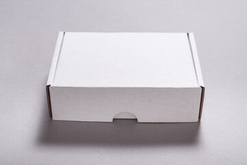 White carton cardboard box for postal shipping on grey background