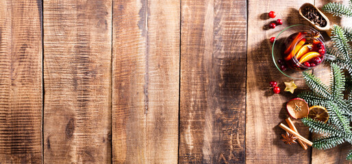 Christmas mulled wine with spices on a wooden rustic table.