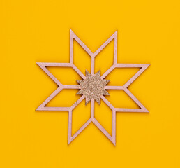 Christmas star decor on yellow colored background.