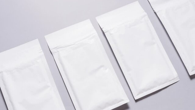 Lot of white paper bubble envelopes on grey background, textured background