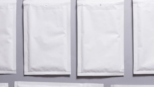 Lot of white paper bubble envelopes on grey background, textured background