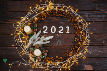 Brown Christmas background in the shape of a circle is decorated with festive Christmas decor and accessories, a garland. Festive new year's card.