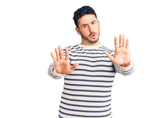 Young hispanic man wearing casual clothes doing stop gesture with hands palms, angry and frustration expression