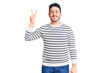 Young hispanic man wearing casual clothes smiling looking to the camera showing fingers doing victory sign. number two.