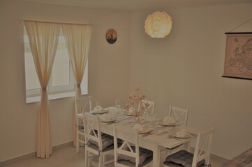 Mali Losinj, Croatia 2020. Dining room interior with table and chairs with dishes.