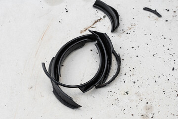 Caliper brake cylinder with a set of destroyed oil seals on white dirty background.