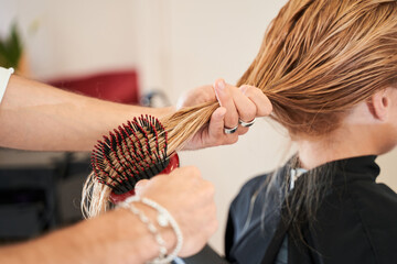 Naklejka premium Professional hairdresser styling the hair