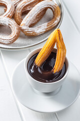 Tasty fried churros with sugar powder and chocolate dip.