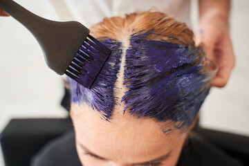 Man holding the brush and brightens the roots of the hair