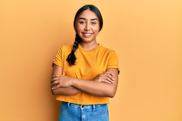 Young latin woman wearing casual clothes happy face smiling with crossed arms looking at the...