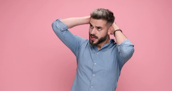 casual young guy feeling nervous, rubbing his head, breathing heavily, loses his temper and screaming, threatening with a fight