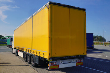 View of the yellow tarpaulin covering the semi-trailer of the truck. Truck transport.