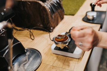 Fototapeta na wymiar Brewing espresso under pressure in a professional coffee machine - the job of a barista in a coffee shop