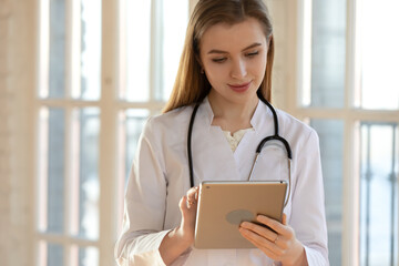 Virtual doctor appointment. Attentive caring millennial female physician family therapist calling patient customer from digital tablet by video link giving recommendations, monitoring state of health