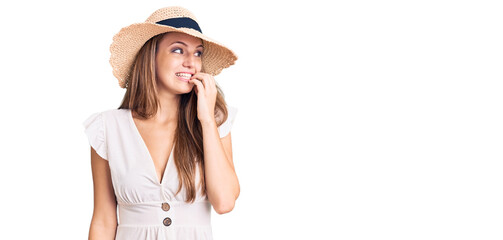 Young beautiful blonde woman wearing summer dress and hat looking stressed and nervous with hands on mouth biting nails. anxiety problem.