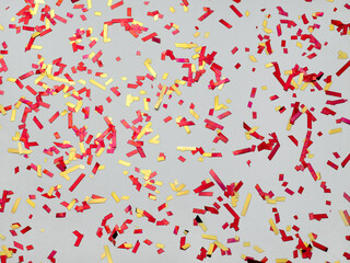 Background confetti red, yellow. Spangles sparkle on pastel gray trendy background. Festive background for your projects