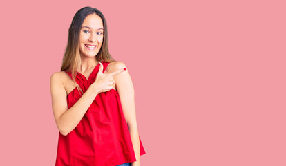 Beautiful brunette young woman wearing casual clothes cheerful with a smile of face pointing with hand and finger up to the side with happy and natural expression on face
