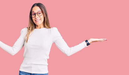 Beautiful brunette young woman wearing casual white sweater and glasses clueless and confused...