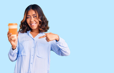 Young beautiful mixed race woman drinking a coffee from take away cup pointing finger to one self smiling happy and proud