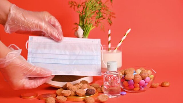 Dutch holiday Sinterklaas. hildrens shoe with carrots for Santa's horse, pepernoten and sweets . Gloved hands are rubbed with antiseptic, sanitizer and a protective mask.