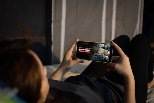 Online Video on demand streaming concept.Female using mobile phone