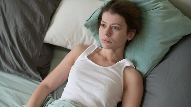 A young woman overslept, looked at the time and hurried to get ready for work or school.