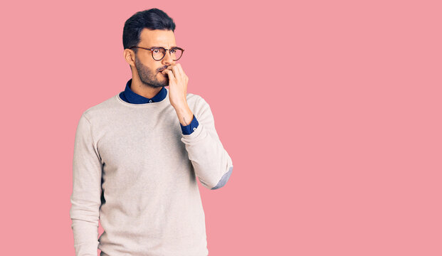 Young handsome hispanic man wearing elegant clothes and glasses looking stressed and nervous with hands on mouth biting nails. anxiety problem.