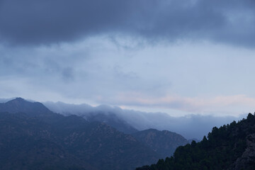 High mountains surrounded by clouds and forests