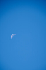 Crescent moon over cloudless blue sky