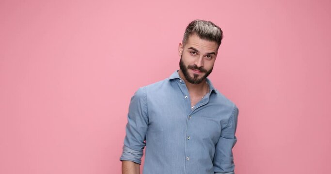 attractive casual man gesturing you, come over here against pink background