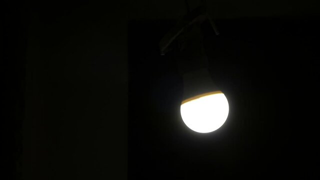 The light bulb is swinging a pendulum