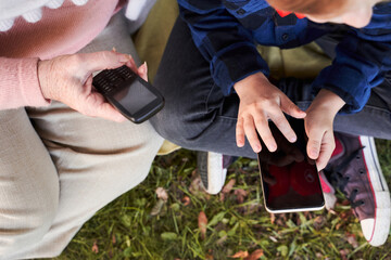Woman and grandson looking at their phones