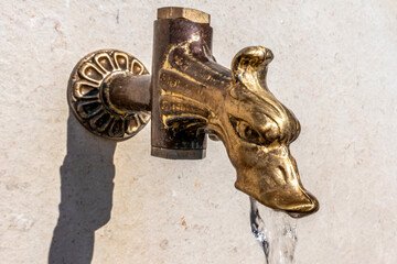 tête de robinet doré dans une fontaine