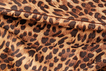 Detail of fashionable handbag from genuine leather embossed under exotic skin of jaguar. Texture, copy space, leather goods concept