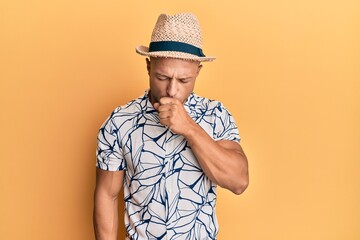 Handsome muscle man wearing summer hat feeling unwell and coughing as symptom for cold or bronchitis. health care concept.