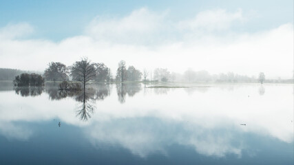A panorama of Soomaa National Park during a autumnal flood also known as the Fifth season in a foggy morning in Estonian nature, Northern Europe.  © adamikarl